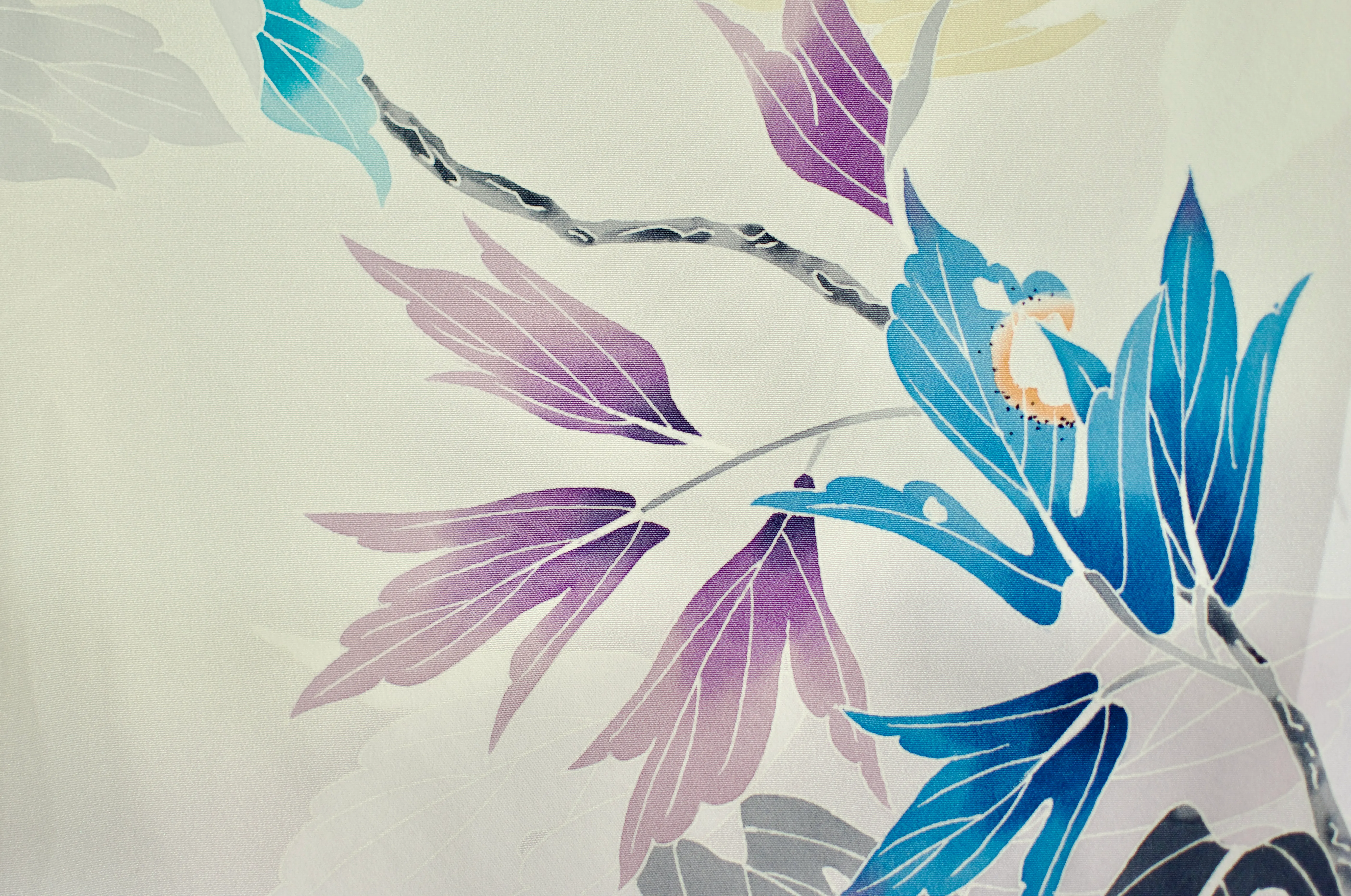A white fabric dyed with blue and purple leaves, with marks suggestive of insect nibble marks