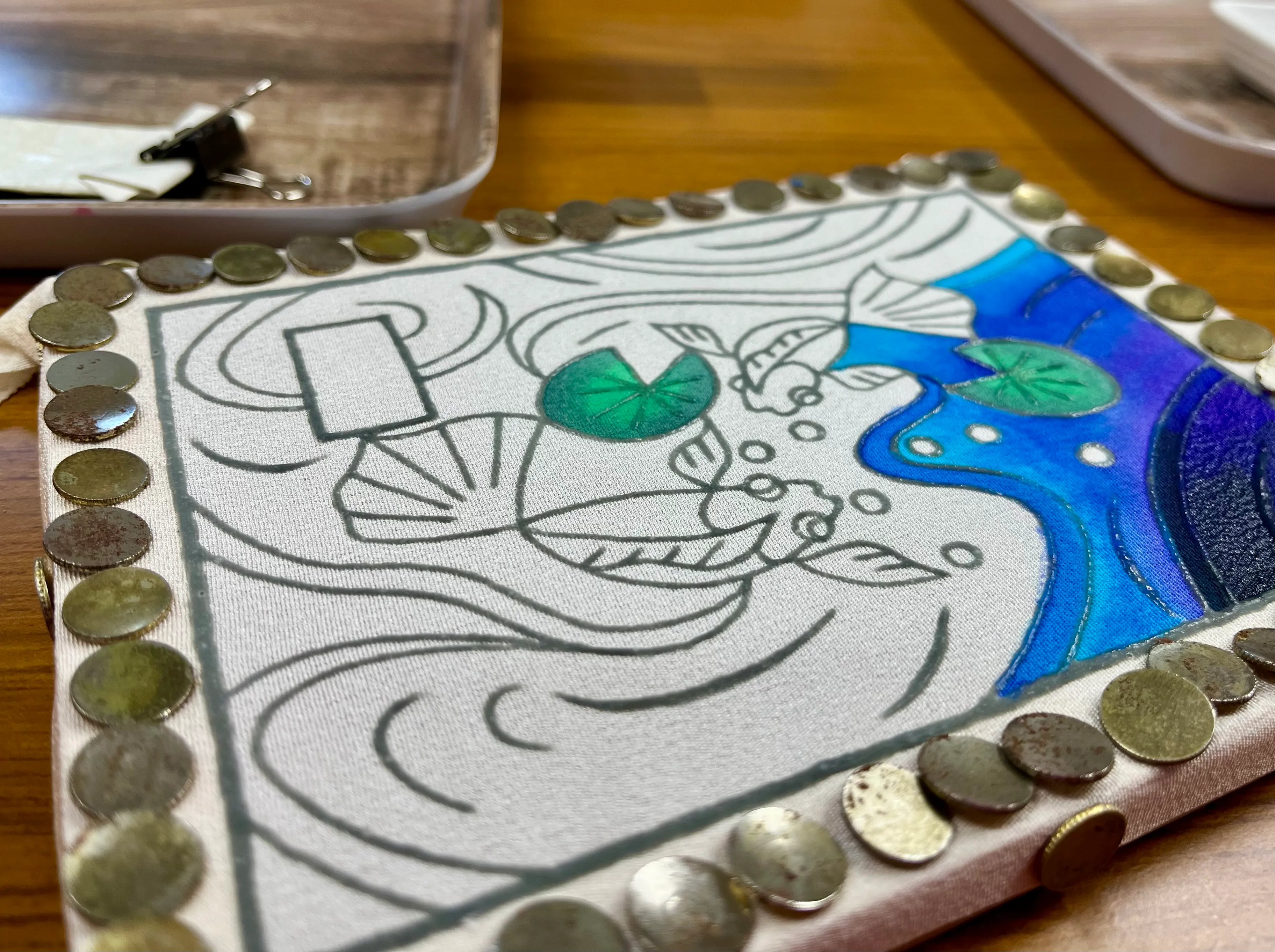 The outlines of fish in water drawn in paste and partially coloured in with dye