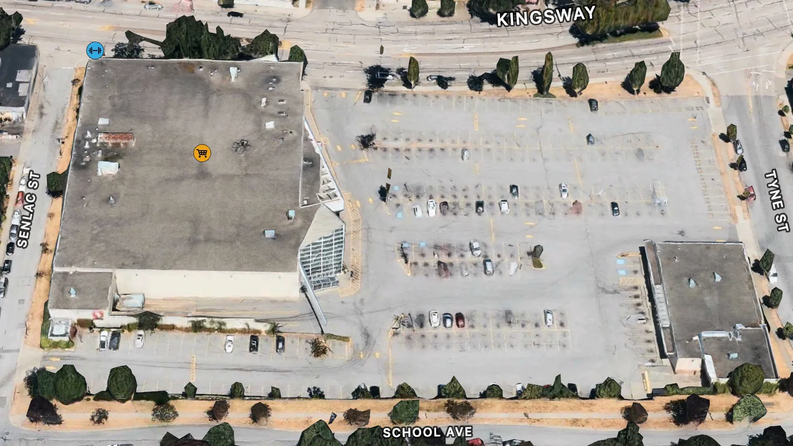 An aerial photo of a supermarket. The building takes up roughly 40% of the image, while the parking lot takes up the rest. There are not very many cars parked in the lot.