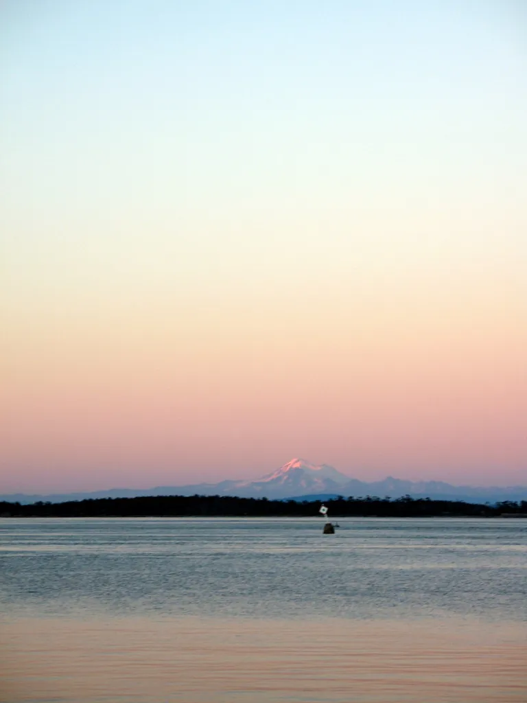 A photo of Kulshan (Mount Baker) at sunset from across the Juan de Fuca Strait