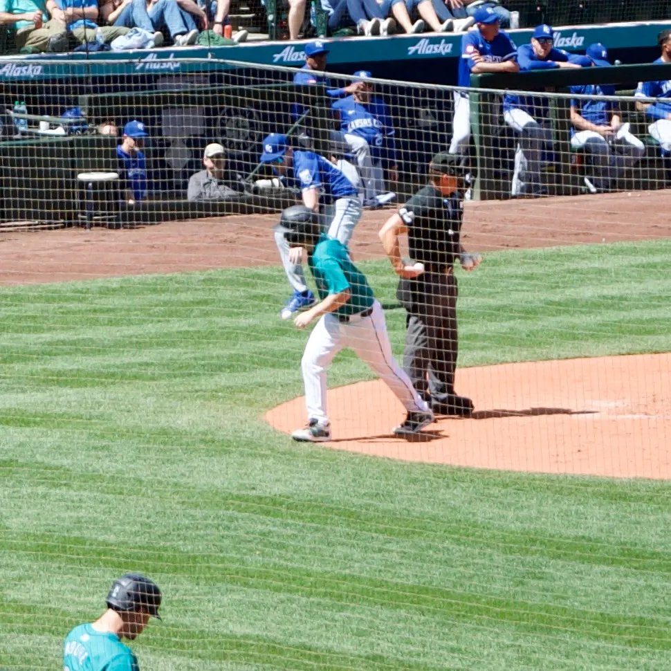 The Seattle Mariners' batboy jogs back to the dugout after supplying the home plate umpire with a half-dozen new balls