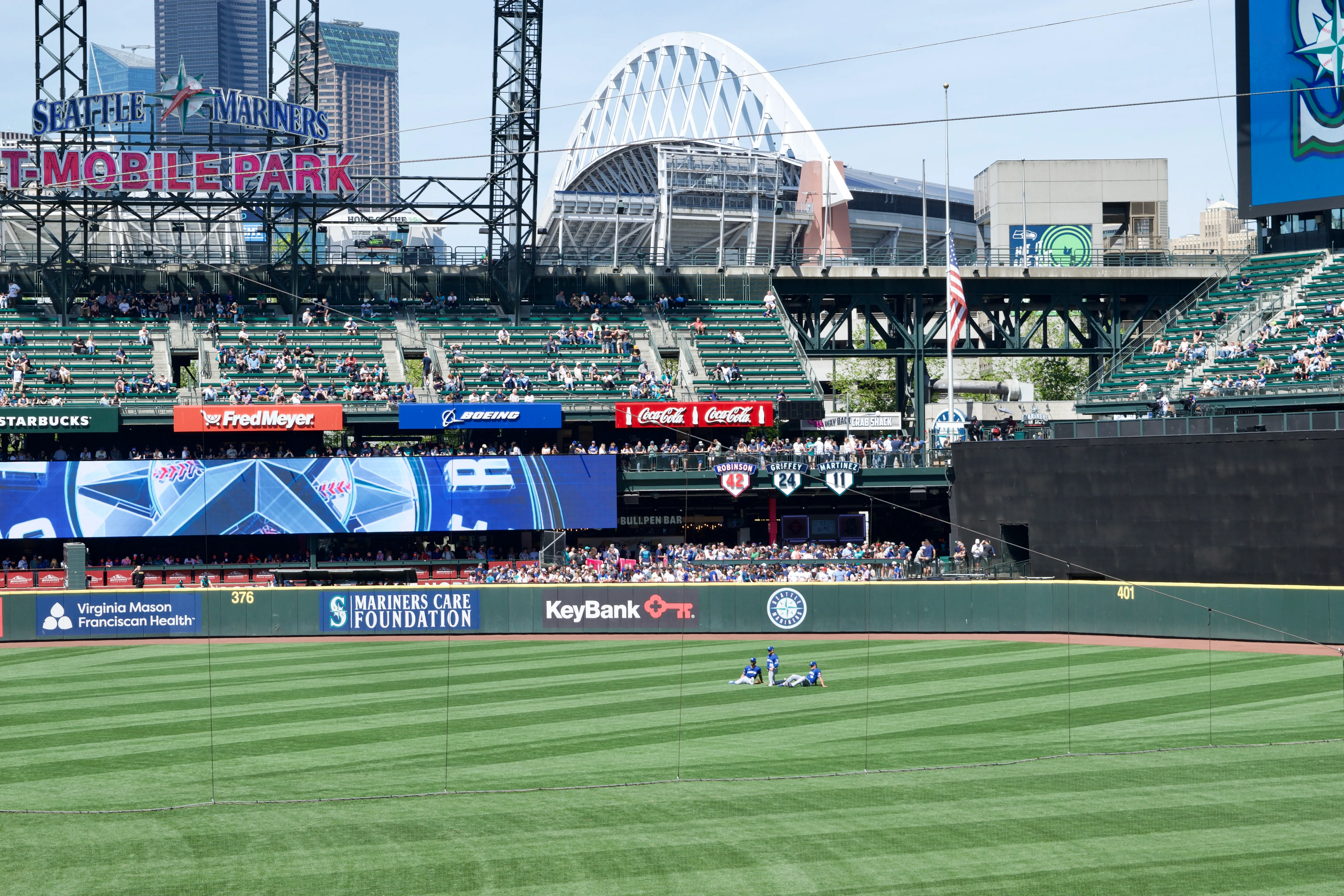 Three Kansas City baseball players sit down in center field