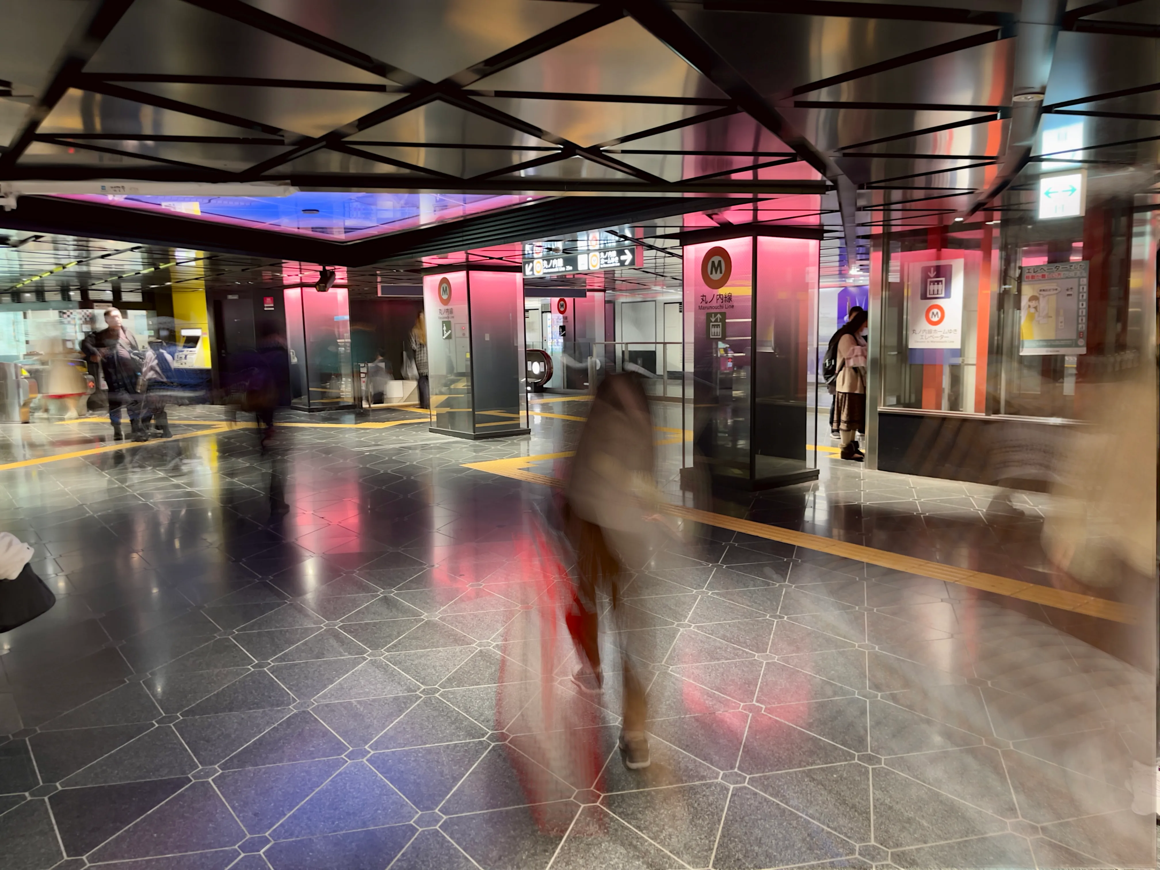 A long-exposure shot of people entering and exiting the Marunōchi Line at Ginza Station