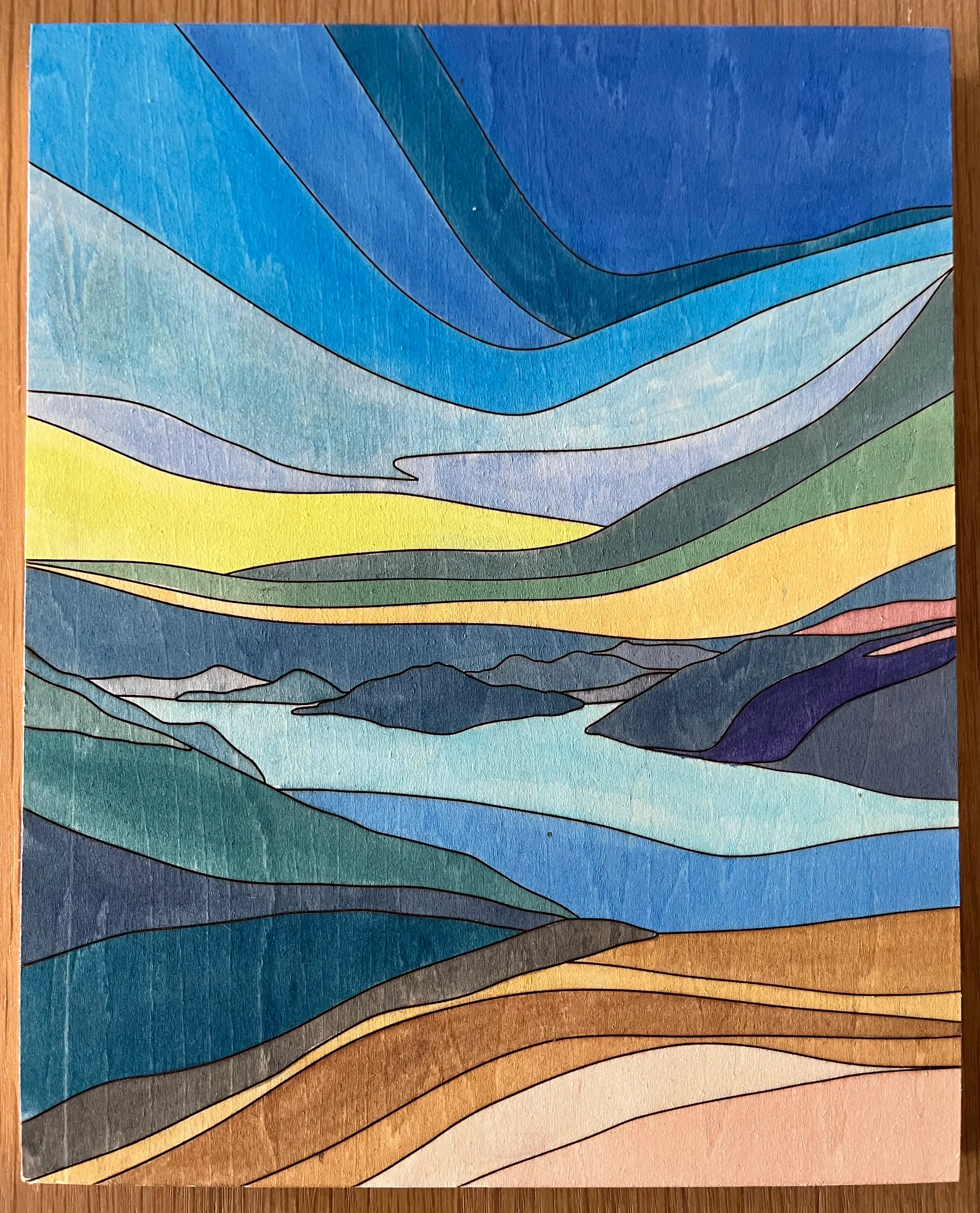 An abstract watercolour-on-wood painting of Átl’ḵa7tsem (Howe Sound) based on a design by Meghan Bellamy