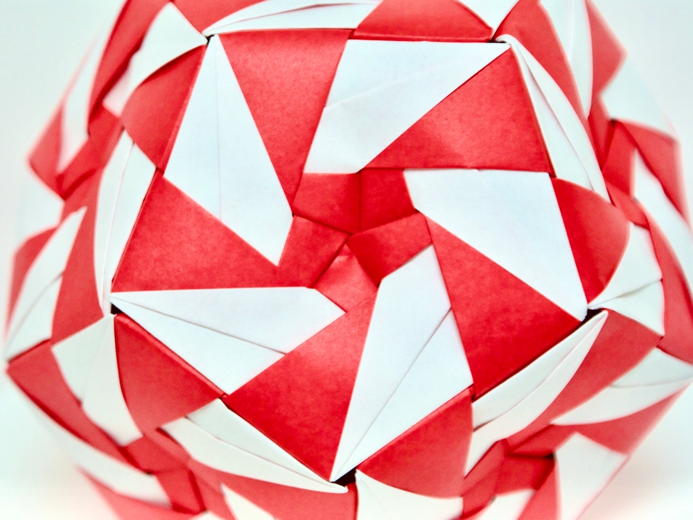 An origami dodecahedron with a red-and-white pinwheel pattern on each face