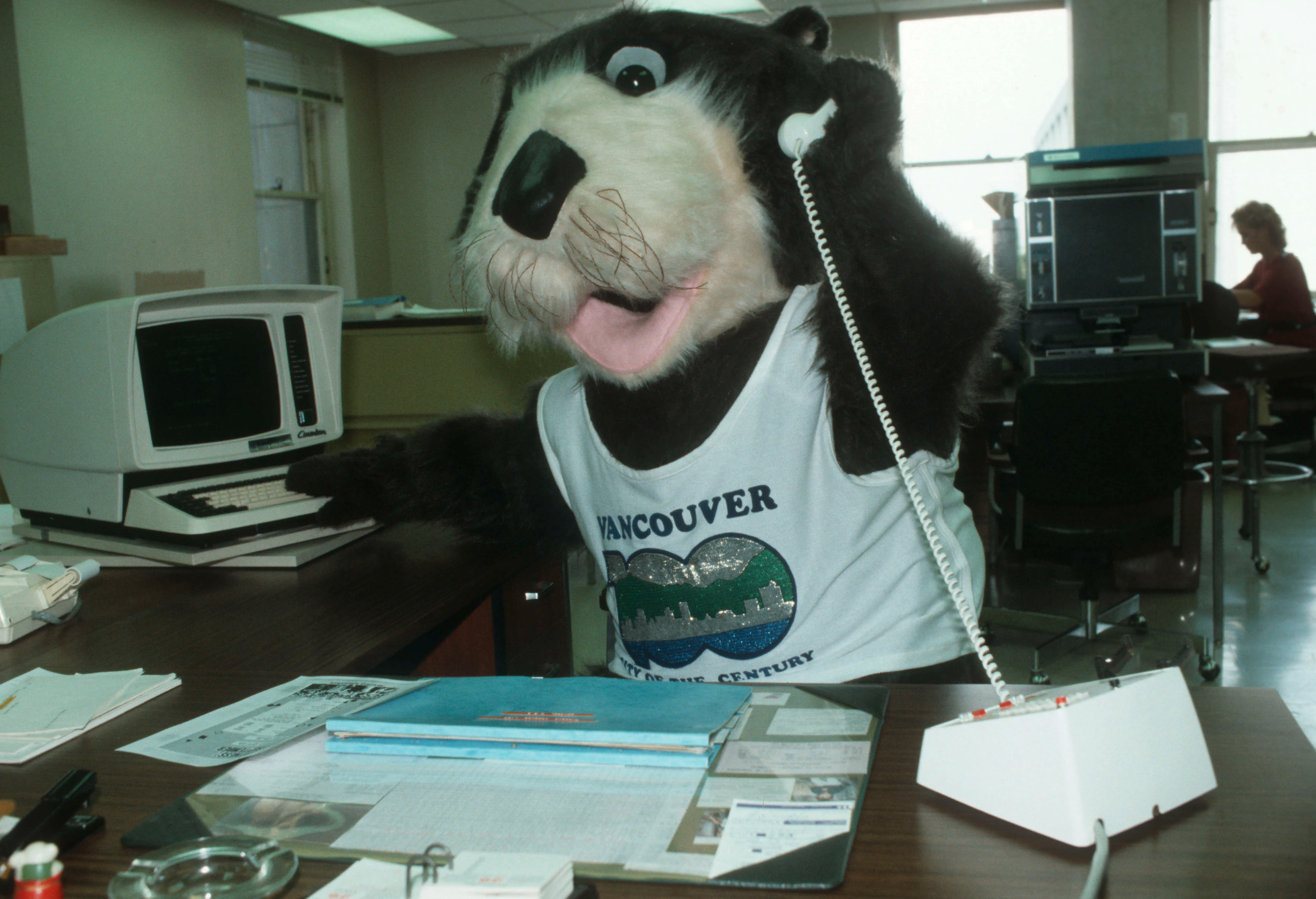 Tillicum on the telephone at an office desk in Vancouver City Hall