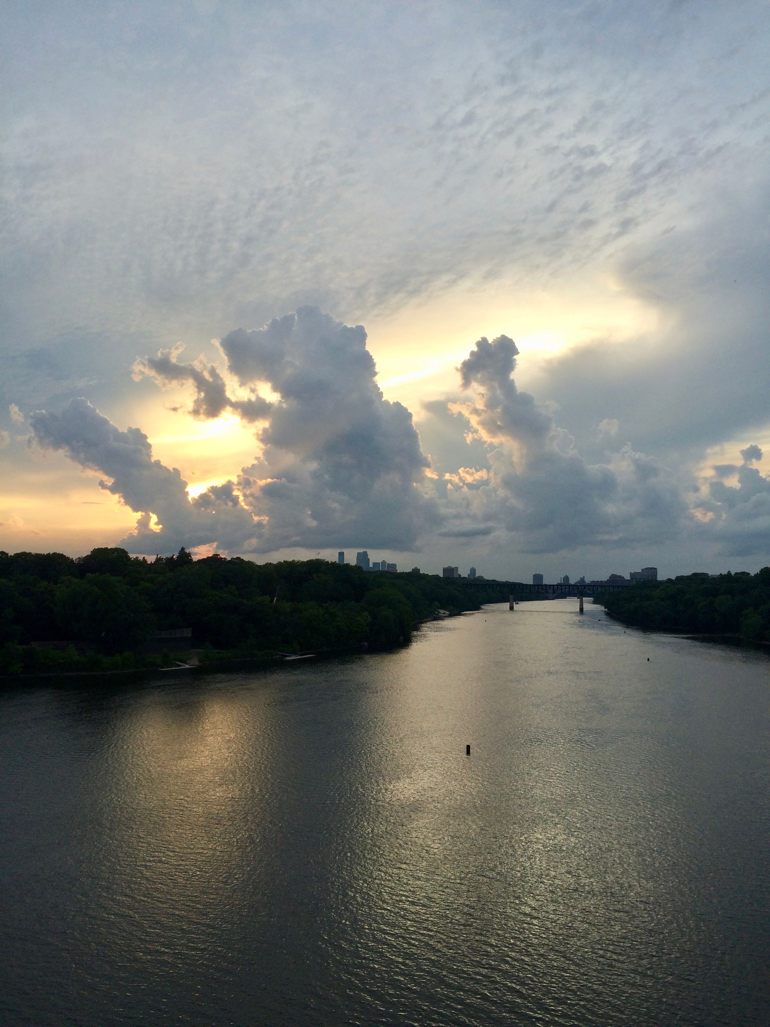 Sunset clouds glow over a calm river