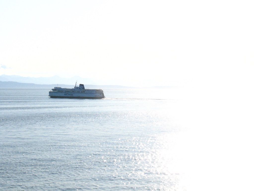 A ferry appears to emerge from a completely white void, i.e. the overexposed white half of the photo.