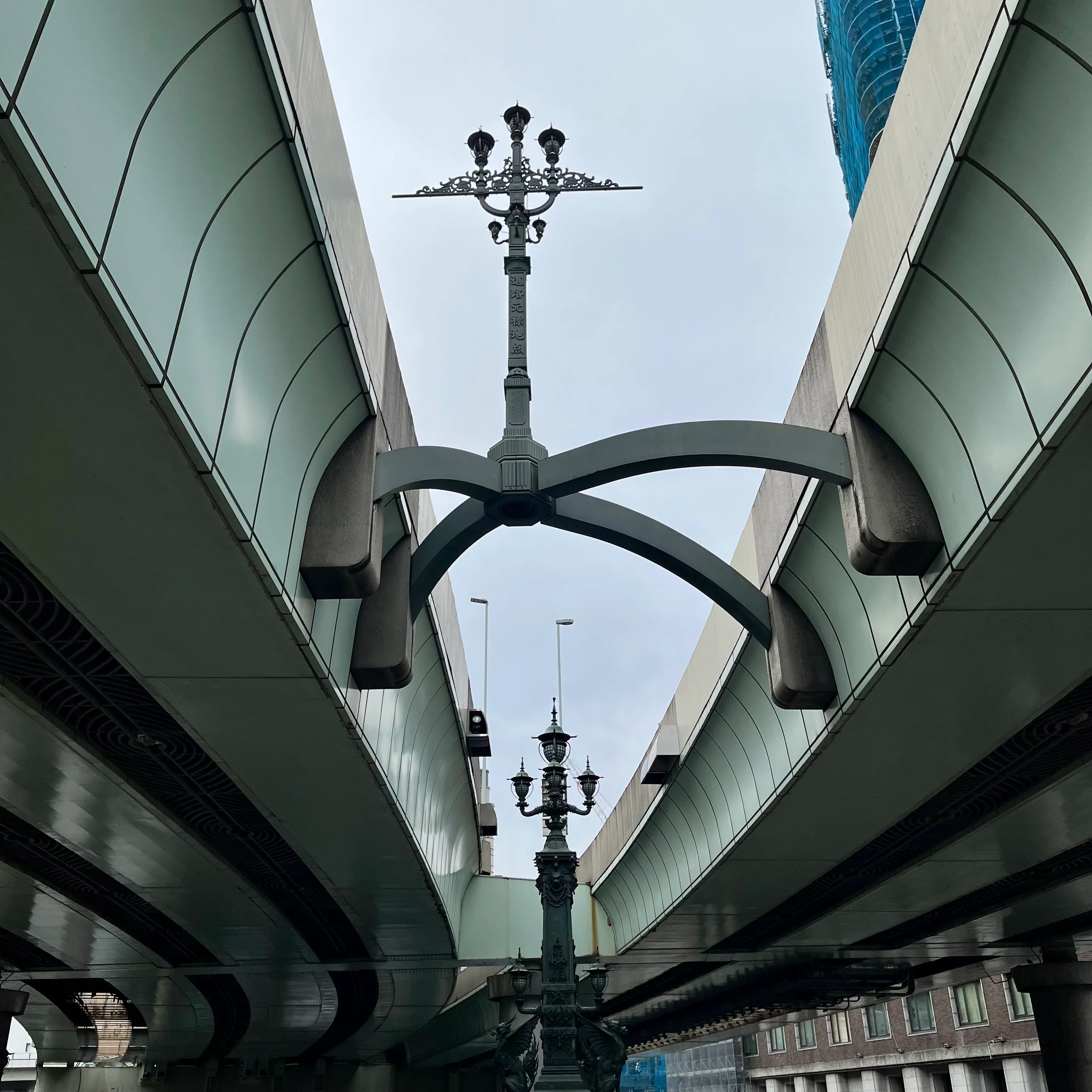 An old-fashioned lamppost suspended between two freeway overpasses