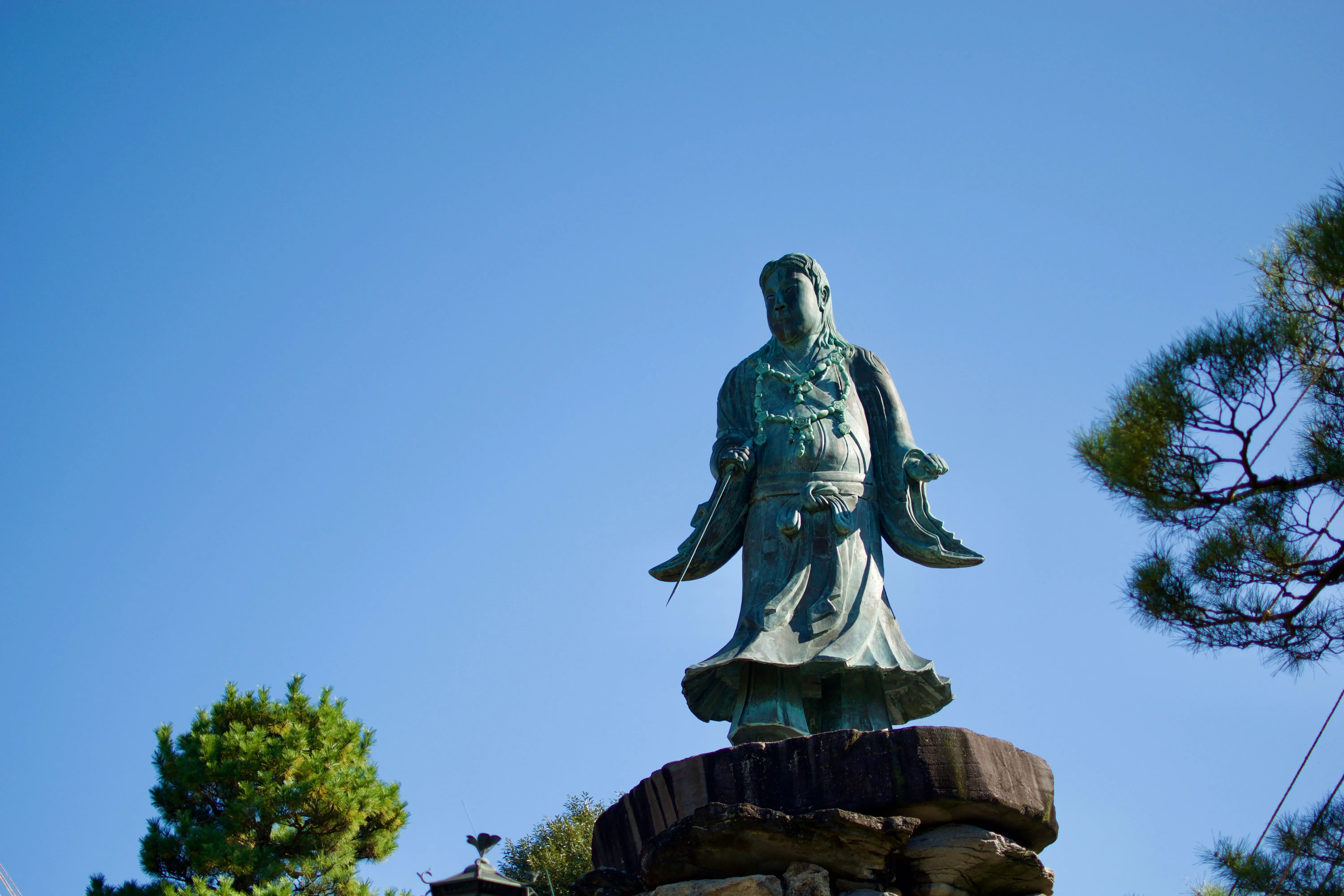 A statue of the legendary prince Yamato Takeru against a clear blue sky