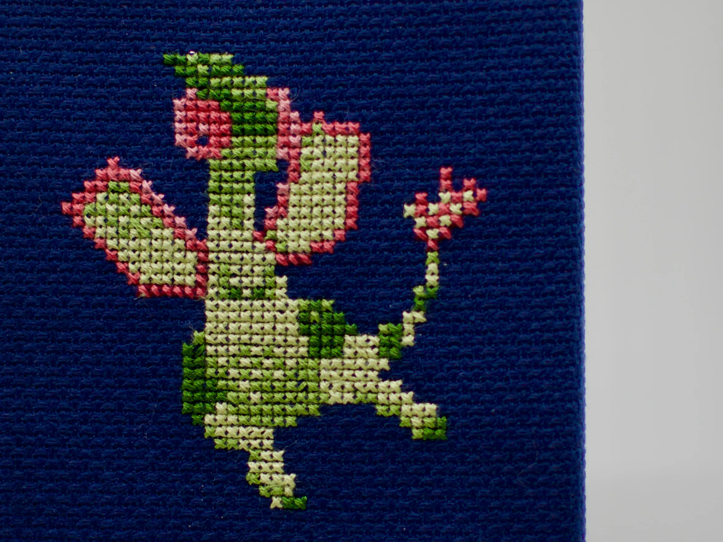 A cross-stitch of the Pokémon Flygon.