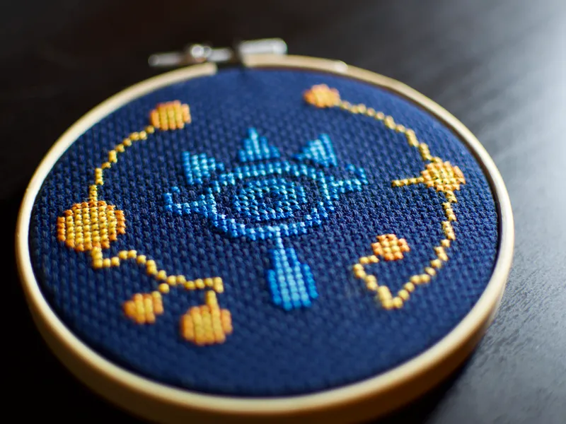 A cross-stitch of the eyelike design found on the Sheikah Slate in The Legend of Zelda: Breath of the Wild.