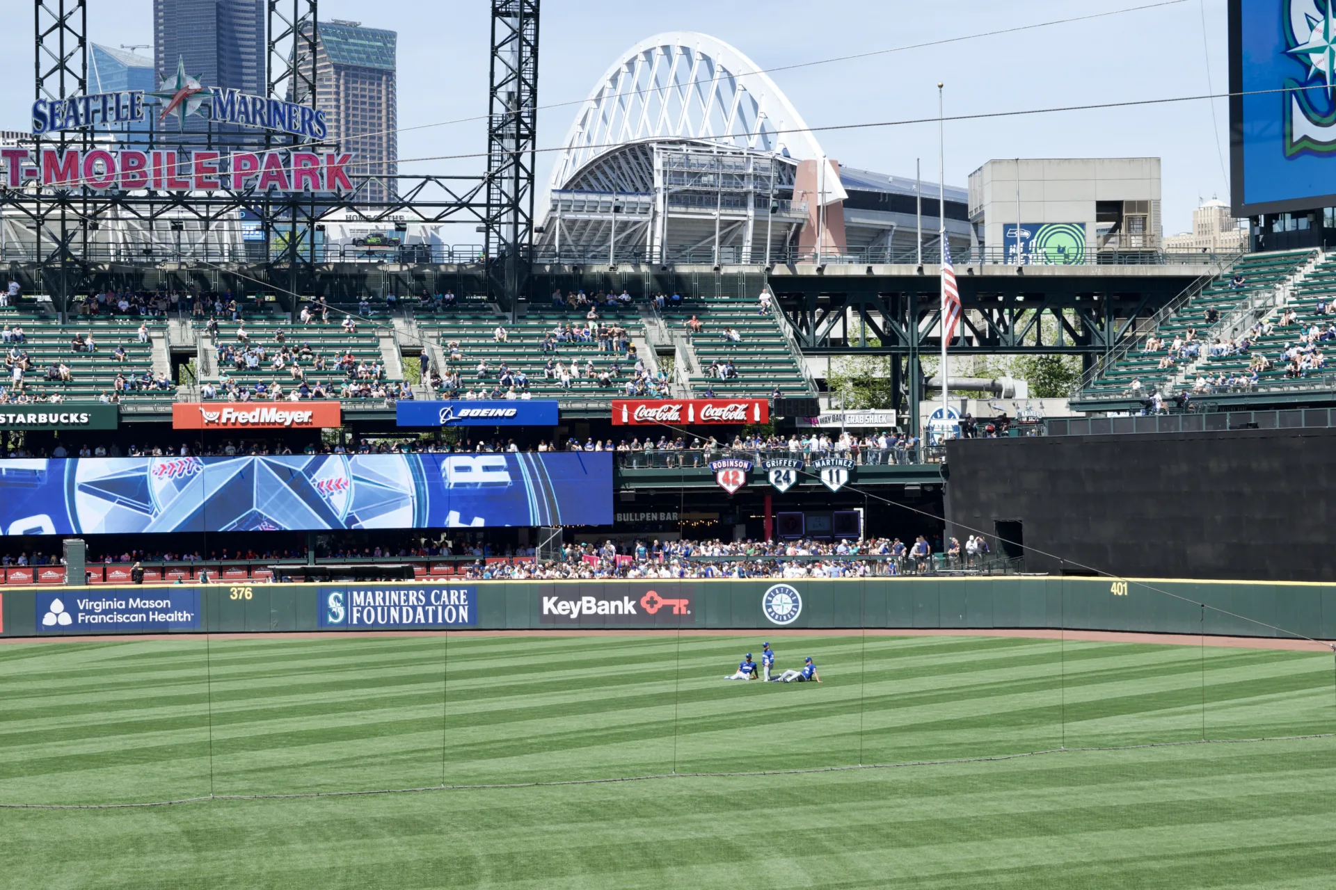 Three Kansas City baseball players sit down in center field.