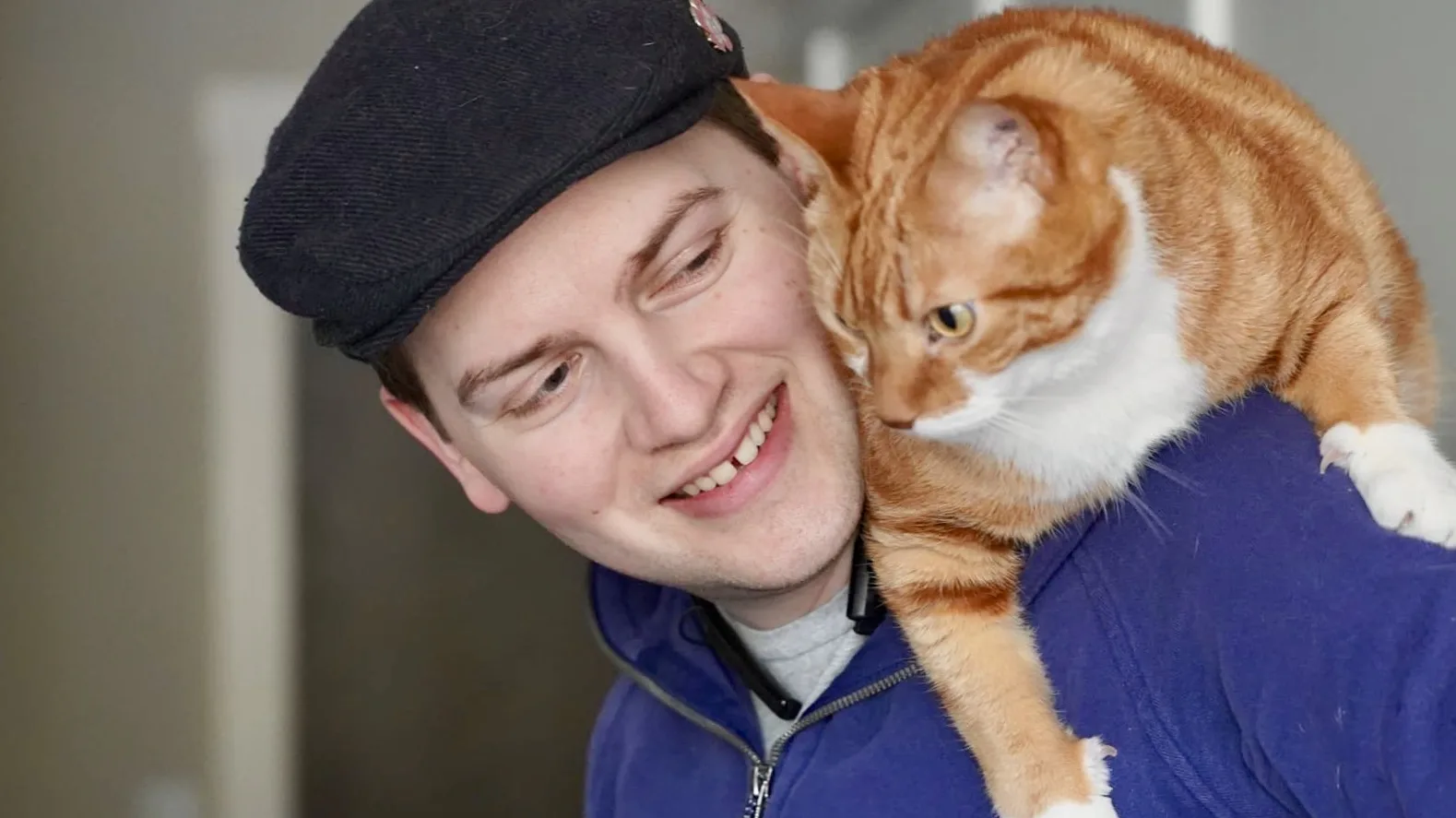 The orange cat Diggy sits on my shoulders.