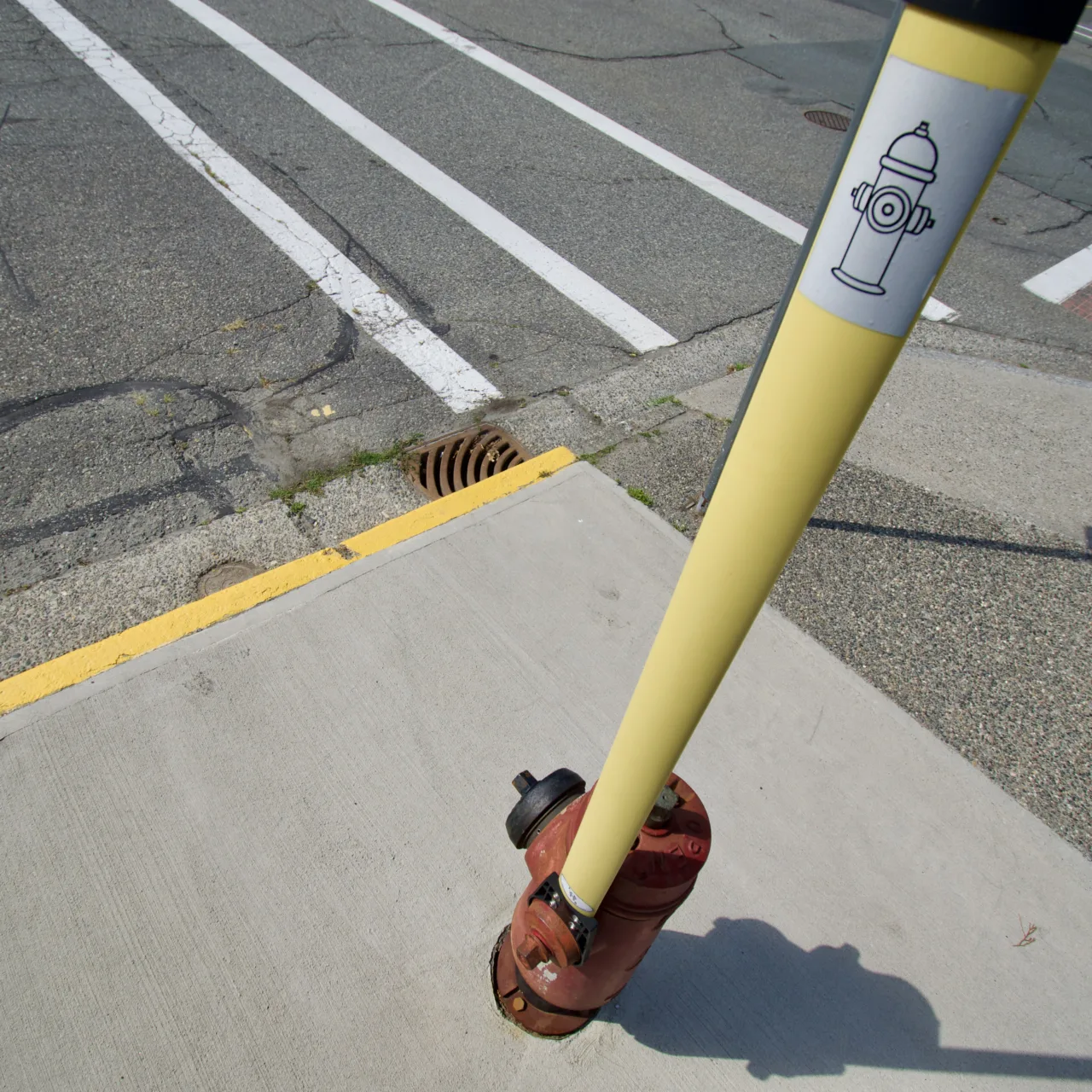 A top-down view along a flat yellow rod attached to a fire hydrant