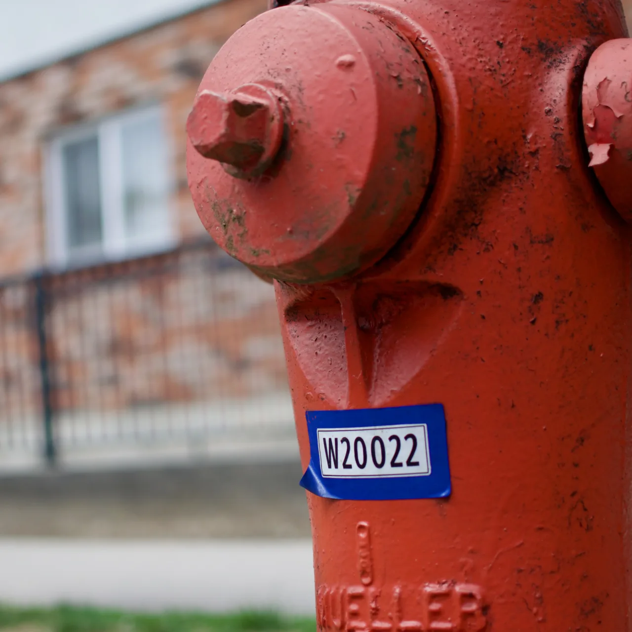 A red fire hydrant with a blue-bordered ID label